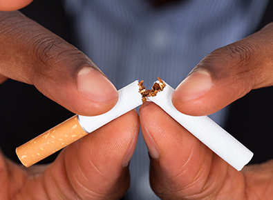 man breaking cigarette in half
